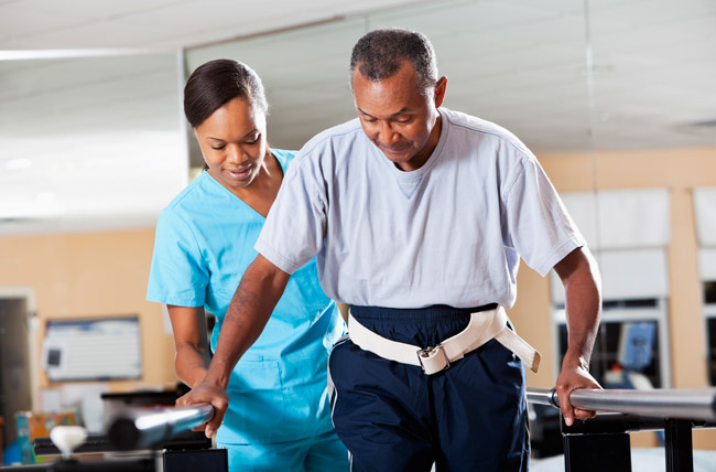 Stock photo of a nurse helping rehab patient to walk